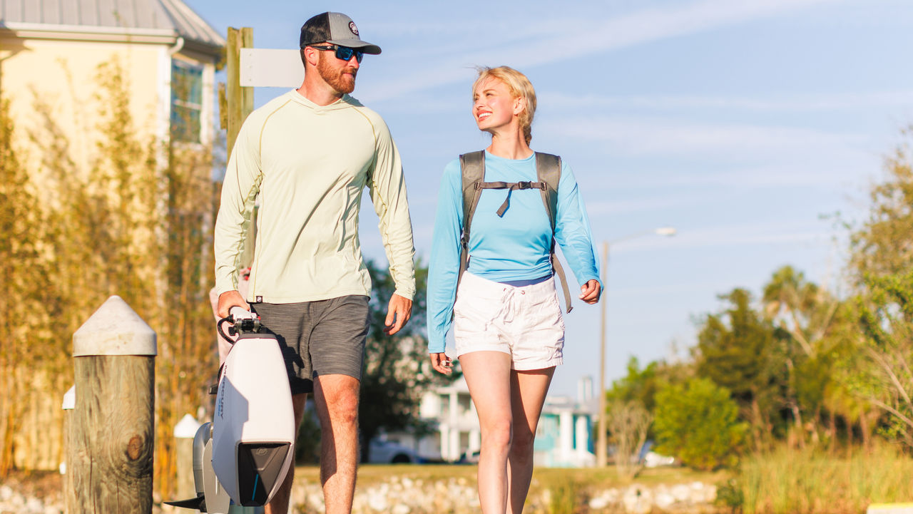 Man and woman walking with an Avator outboard