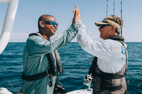 fishermen high fiving on boat